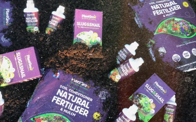 PlantGrow organic fertiliser and slug snail products arranged on soil, showcasing natural gardening solutions for sustainable plant care.