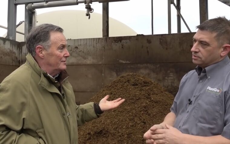 RHS Judge Martin Fish examining natural fertiliser with PlantGrow representative at composting facility.